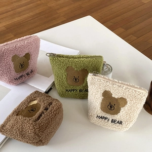 Detail showing plush teddy bear makeup pouches in pink, green, brown and white colors