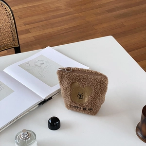Close-up of brown plush teddy bear makeup bag with Happy Bear embroidery and zipper