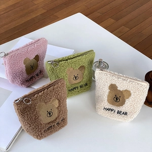 Detail of plush bear cosmetic bags in pink, green, brown, and cream with zipper rings