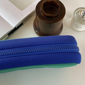 Macro shot of blue chunky zipper and woven fabric texture on a large cosmetic bag