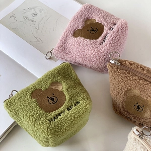 Macro shot of plush bear makeup bags with Happy Bear embroidery and ring zippers