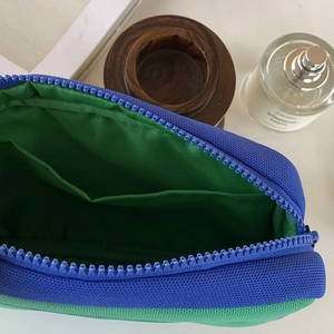 Detail view of the blue and green nylon makeup bag showing inner compartment and zipper