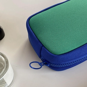 Close-up of blue and green color-block makeup bag with durable nylon mesh texture