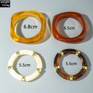 Detail view of resin bangle set with weight and diameter specs on a gray background