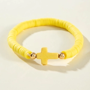 Vue détaillée du bracelet en perles Heishi jaunes avec un pendentif croix dorée