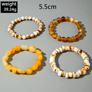 Detail of four-piece bohemian multilayered acrylic beaded bracelets with amber resin texture
