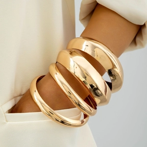 Gros plan de gros bracelets manchettes dorés empilables avec finition métal poli