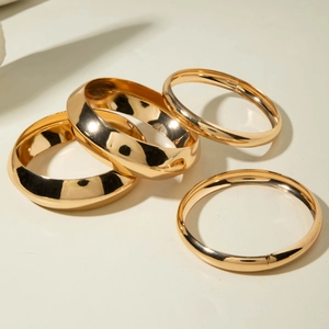 Détails d'un ensemble de quatre bracelets dorés avec finition miroir haute brillance