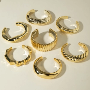Détail du lot de 7 bracelets joncs dorés aux finitions texturées, ondulées et polies