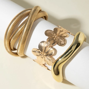 Ensemble de trois bracelets punk dorés avec motifs floraux et textures métalliques