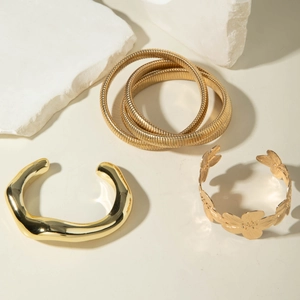 Vue détaillée de trois joncs dorés de style punk sur d'élégants blocs de marbre