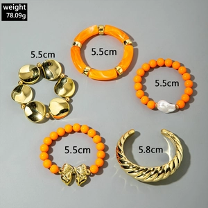 Vue détaillée de l'ensemble de cinq bracelets dorés et orange avec nœud et manchette