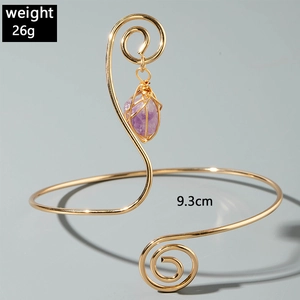 Detail view of gold spiral arm cuff with purple gemstone weighing 26g and 9.3cm inner diameter
