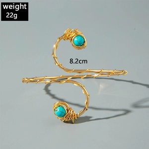 Detailed macro view of bohemian spiral arm cuff with turquoise beads and wire wrapping