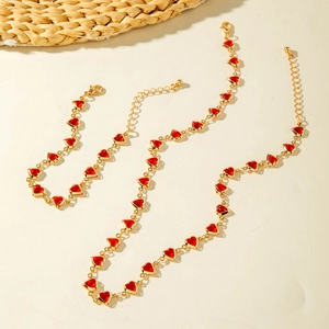 Elegant gold chain jewelry set featuring red heart charms with necklace and bracelet