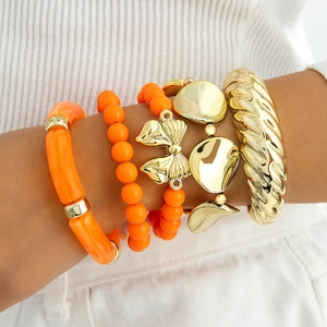 Ensemble de quatre bracelets en perles orange marbré et un jonc doré en spirale