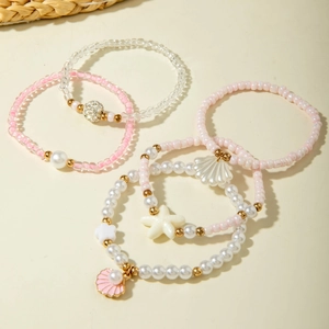 Ensemble de cinq bracelets en perles roses et blanches avec charms étoile de mer