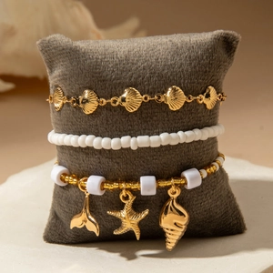 Three-piece bohemian beach anklet set with gold starfish, seashell, and white beads