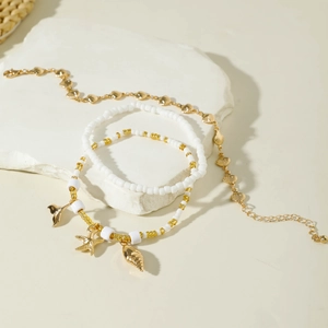 Detail of three-piece bohemian beach anklet set with starfish and seashell charms