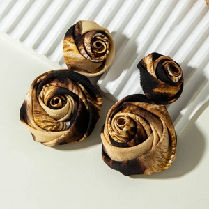 Leopard print fabric flower earrings set in three sizes on a minimalist white display
