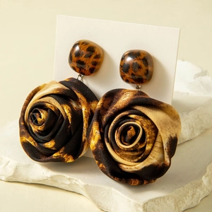 Macro detail of leopard print fabric flower earrings with resin stud and vintage style