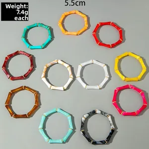 Dettaglio di bracciali in acrilico marmorizzato colorato con distanziatori dorati