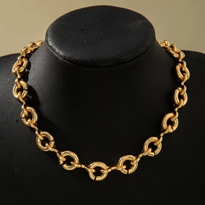 Close-up of polished gold thick chunky chain necklace on a black neck display