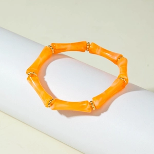 Bracciale elastico a tubo di bambù con perline acriliche arancioni e distanziali dorati
