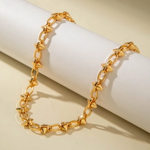 Close-up of punk gold spiked choker necklace on display stand with sharp shadows