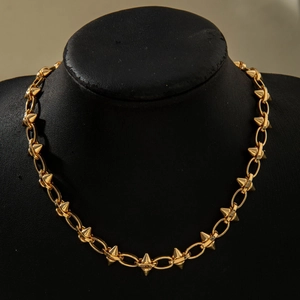 Macro shot of gold punk chunky chain necklace with interlocking metal spikes on black neck model