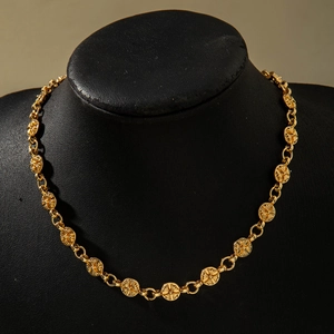 Close-up of golden punk hip hop chain with intricate cross pattern relief details