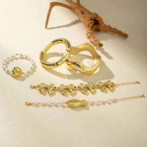 Ensemble de cinq bracelets dorés avec perles et nœuds dans un style vintage chic