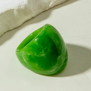 Detailed view of wide green acrylic resin ring with white marble texture on stone