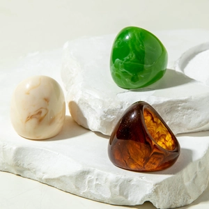Three minimalist acrylic resin rings in marble, green and amber tortoise shell finish