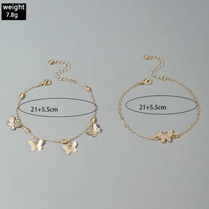 Detail of gold butterfly anklet set with rhinestone charms and bead accents