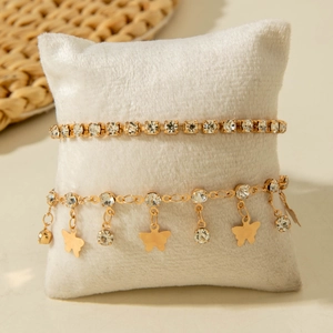 Close-up of a double-layered gold butterfly anklet set with sparkling rhinestones