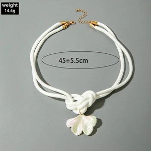 Détail du collier en corde nouée avec pendentif feuille de ginkgo nacré et fermoir doré