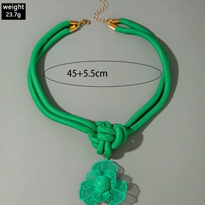 Détail du collier en corde tressée verte avec nœud concentrique et pendentif fleur