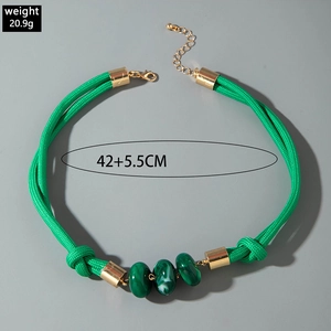Vue détaillée du collier en cordon tressé vert avec perles résine et accents dorés