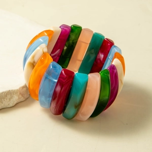 Detail of colorful resin beaded bracelet with marbled texture on neutral stone background