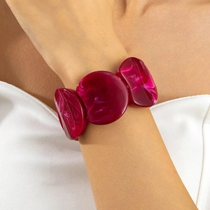 Detail of chunky magenta resin bracelet with marble texture worn on model wrist