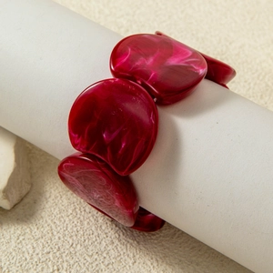 Detail of red marble texture resin beads on an elastic stretch bracelet close-up view