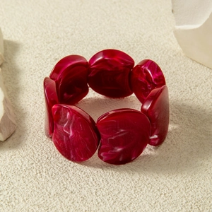 Close-up of deep red elastic beaded bracelet with chunky marble-textured resin stones
