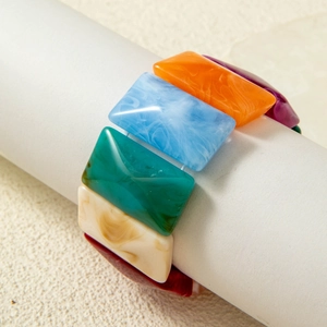 Macro shot of colorful acrylic beaded bracelet with marble texture and faceted cubes
