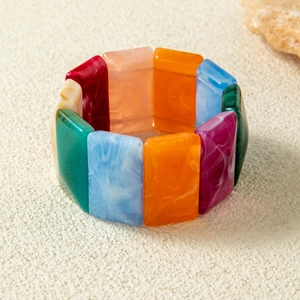 Close-up of colorful acrylic elastic bracelet with marbled texture in retro style