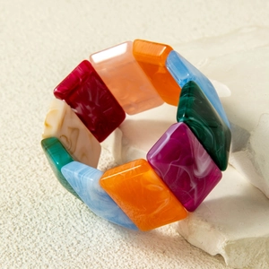 Close-up of multicolored acrylic stretch bracelet with marbled texture and vintage tiles