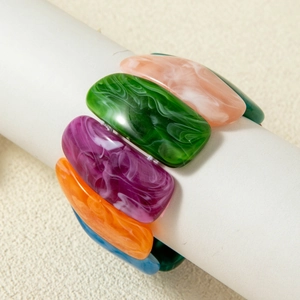 Close-up of colorful marble texture acrylic resin beads on an elastic stretch bracelet