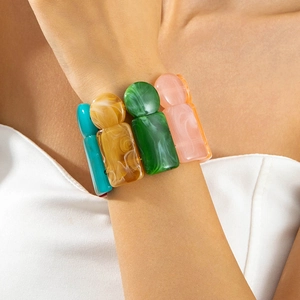 Close-up of a stacked colorful acrylic resin geometric bead bracelet set on a wrist