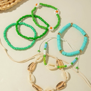 Detail of bohemian shell and bead bracelets set with starfish and evil eye charms