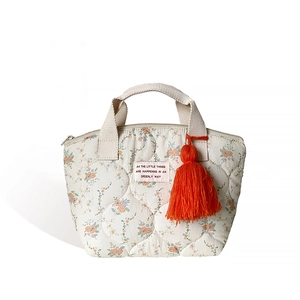 Sac à déjeuner matelassé à fleurs avec pompon orange et poignées tissées blanches